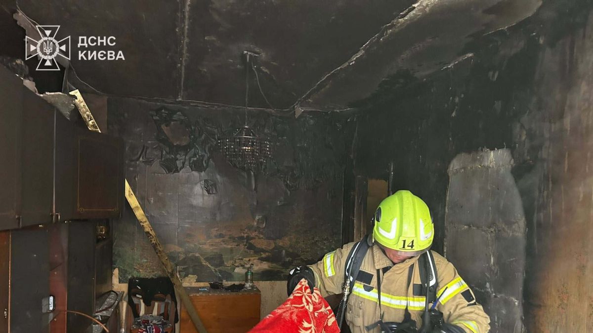 Рятувальник ДСНС у вигорілій квартирі на третьому поверсі п'ятиповерхового будинку на вулиці Набережно-Луговій у Подільському районі Києва