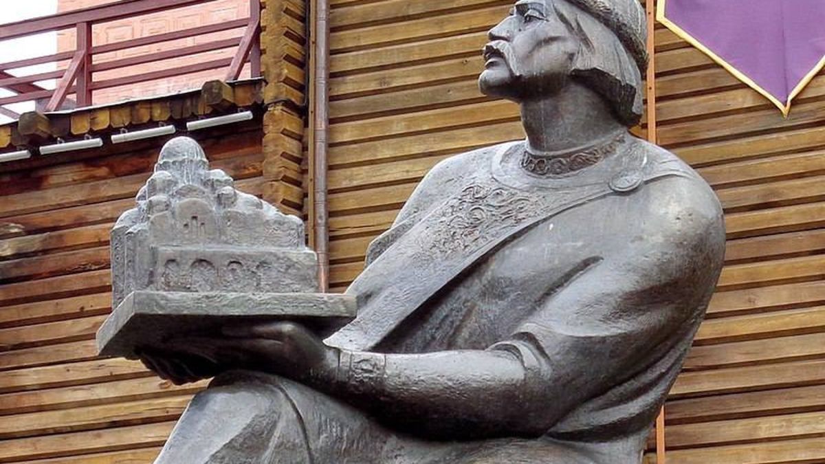 Бронзова скульптура князя Ярослава Мудрого, який тримає в руках макет Софійського собору, на фоні дерев'яної стіни